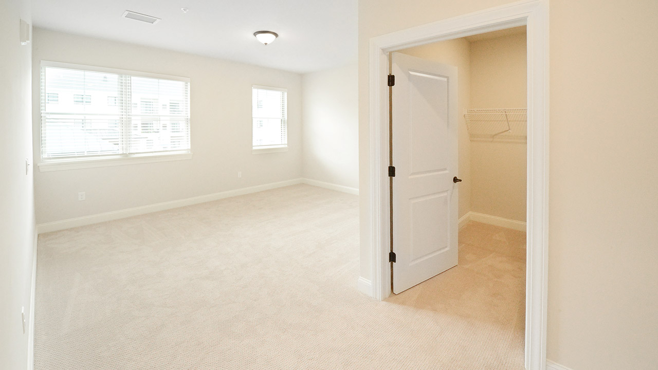bedroom with lots of light from windows, closet entrance on right